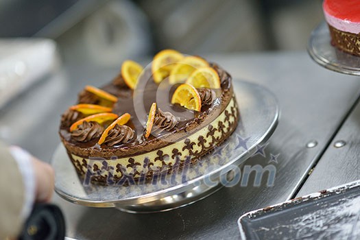 Closeup of a concentrated male pastry chef decorating dessert cake food in the kitchen Closeup of a concentrated male pastry chef decorating dessert cake food in the kitchen