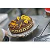 Closeup of a concentrated male pastry chef decorating dessert cake food in the kitchen