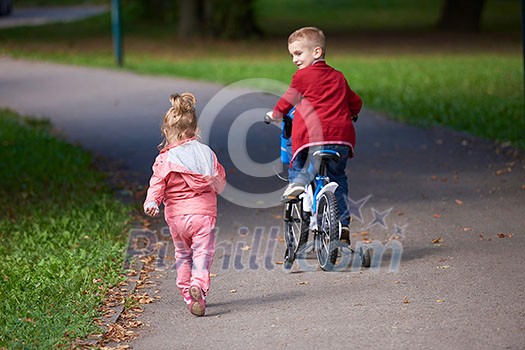 happy kids in park, boy and girl in nature with bicycle have fun happy kids in park, boy and girl in nature with bicycle have fun