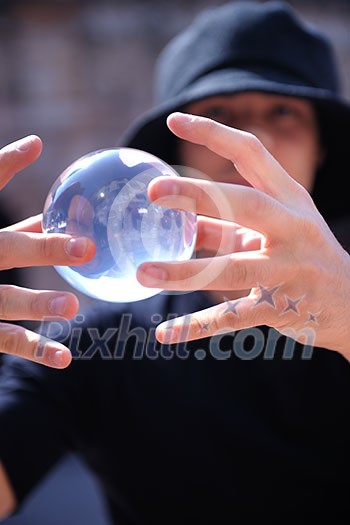 young man balancing glass globe bal with hands