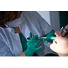 Closeup of a woman patient at the dentist waiting to be checked up with the woman doctor in the background