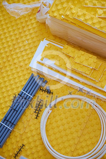 yellow underfloor heating posed in a under construction building