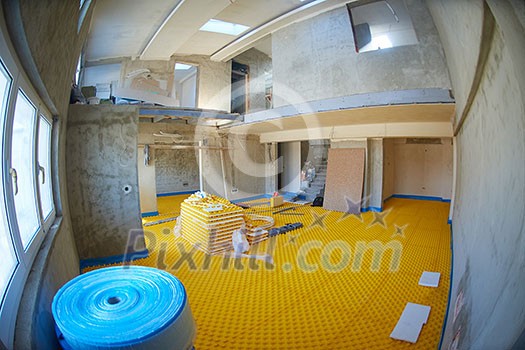 yellow underfloor heating posed in a under construction building