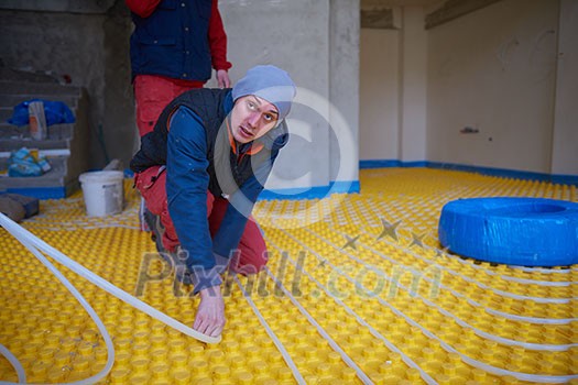 grouo of workera installing underfloor heating and colling in modern home grouo of workera installing underfloor heating and colling in modern home