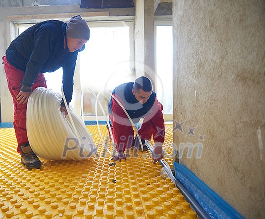 grouo of workera installing underfloor heating and colling in modern home grouo of workera installing underfloor heating and colling in modern home