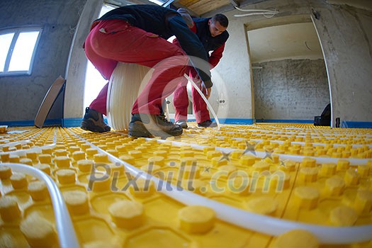 grouo of workera installing underfloor heating and colling in modern home grouo of workera installing underfloor heating and colling in modern home