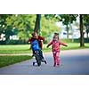 happy kids in park, boy and girl in nature with bicycle have fun