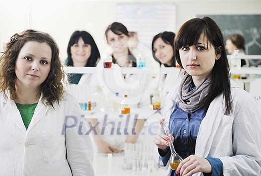 young woman students group in bright chemistry lab young woman students group in bright chemistry lab