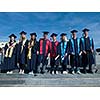 young graduates students group  standing in front of university building on graduation day