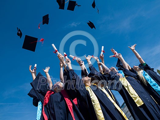 high school students graduates tossing up hats over blue sky. high school students graduates tossing up hats over blue sky.