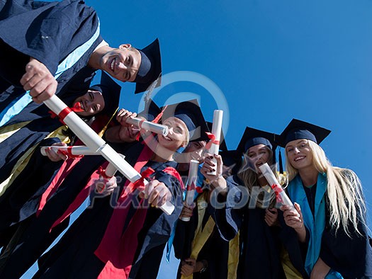 high school students graduates tossing up hats over blue sky. high school students graduates tossing up hats over blue sky.