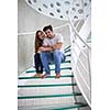 relaxed young couple on spiral glass stairs in modern home villa indoors