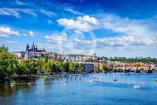 Vltava river and Gradchany Prague Castle and St. Vitus Cathedral and Charles bridge with people in paddle boats. Prague, Czech Republic