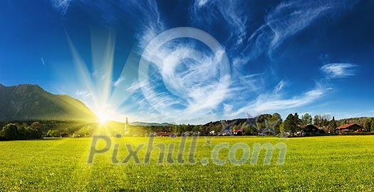 Panorama of German countryside and village on sunset with sun. Bavaria, Germany