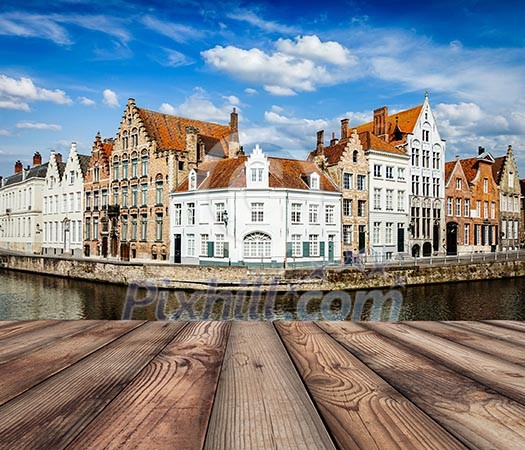 Wooden planks with European view of  Bruges canal and old historic houses of medieval architecture in background. Brugge, Belgium