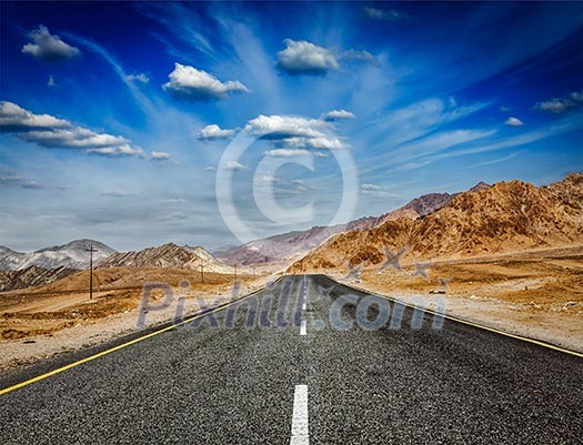 Travel forward concept background - road in Himalayas with mountains and dramatic clouds. Ladakh, Jammu and Kashmir, India