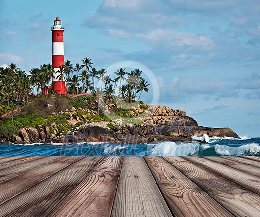 Wood planks floor with old lighthouse and sea waves in background Wood planks floor with old lighthouse and sea waves in background