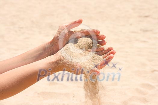 Sand running through hands on beach Sand running through hands on beach
