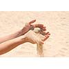 Sand running through hands on beach