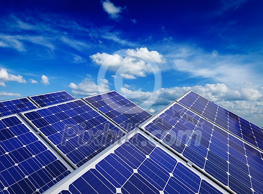 Solar power generation technology, alternative renewable energy and environment protection ecology concept - close up of solar battery panels against blue sky with clouds Solar power generation technology, alternative renewable energy and environment protection ecology concept - close up of solar battery panels against blue sky with clouds