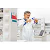 Senior male researcher carrying out scientific research in a lab (shallow DOF; color toned image)