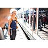 Pretty, young woman in a trainstation, waiting for her train, boarding a train (color toned image)