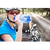 Pretty, young female biker outdoors on her mountain bike (shallow DOF; selective focus)