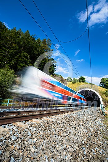 Fast train passing through a tunnel on a lovely summer day (motion blurred image)