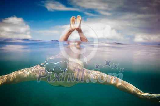 Young male snorkeler divingin the sea Young male snorkeler divingin the sea