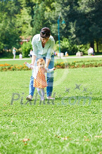 happy mother and baby child in park making first steps . Walking and hugging. happy mother and baby child in park making first steps . Walking and hugging.