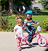 Happy childrens outdoor,  brother and sister in park have fun. Boy and girl in park learning to ride a bike.