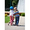 Happy childrens outdoor,  brother and sister in park have fun. Boy and girl in park learning to ride a bike.