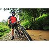 young man drive mountain bike over water river