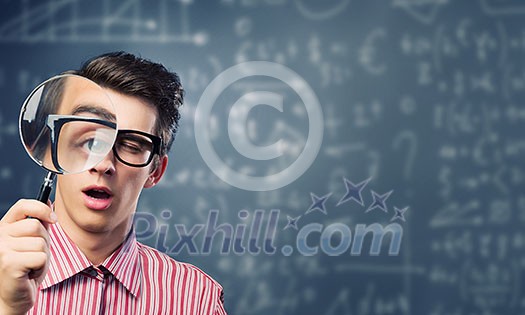 Young man scientist looking in magnifying glass