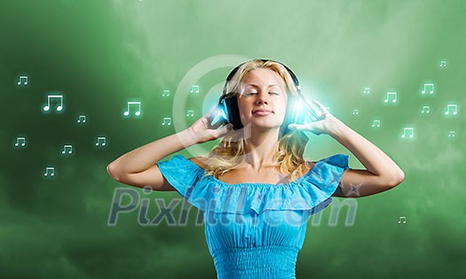 Young blond girl in blue dress listening music