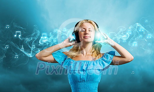 Young blond girl in blue dress listening music