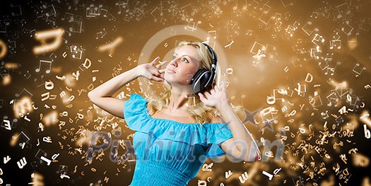 Young blond girl in blue dress listening music