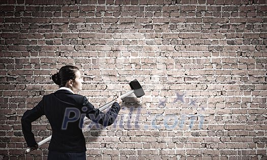 Young attractive businesswoman with hammer in hands