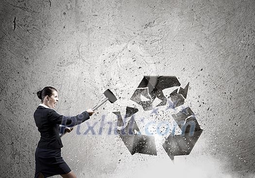 Young businesswoman in anger crashing stone recycle symbol Young businesswoman in anger crashing stone recycle symbol