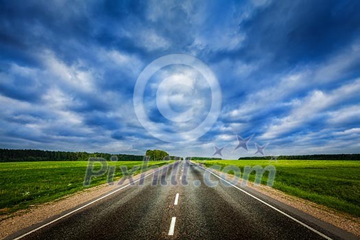 Travel concept background - road under dramatic stormy cloudy sky