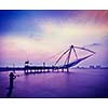 Vintage retro hipster style travel image of Kochi chinese fishnets on sunset. Fort Kochin, Kochi, Kerala, India