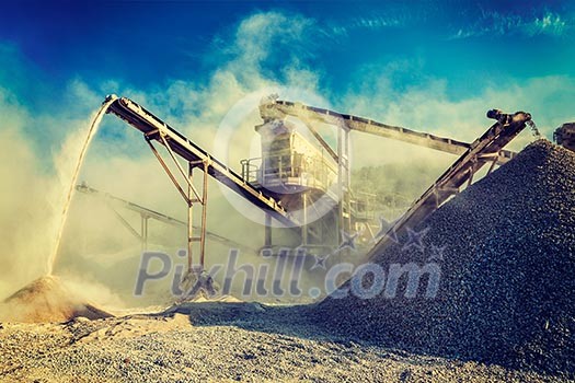 Vintage retro effect filtered hipster style image of Industrial background - crusher rock stone crushing machine at open pit mining and processing plant for crushed stone, sand and gravel