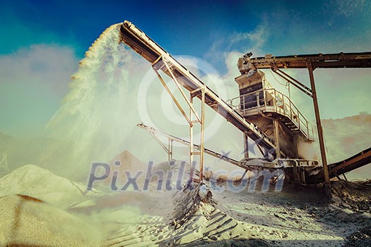 Vintage retro effect filtered hipster style image of Industrial background - crusher rock stone crushing machine at open pit mining and processing plant for crushed stone, sand and gravel