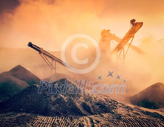 Vintage retro effect filtered hipster style image of Industrial hell pollution concept - crusher rock stone crushing machine at open pit mining and processing plant for crushed stone sand and gravel