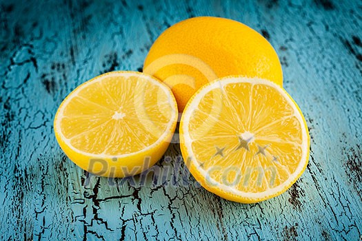 Lemon and cut half slice on blue wooden background Lemon and cut half slice on blue wooden background