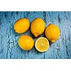 Five fresh ripe yellow lemons on blue wooden background