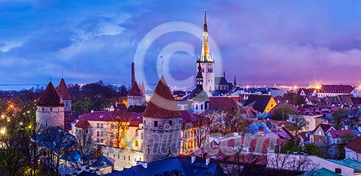 Panorama of aerial view of Tallinn Medieval Old Town with St. Olaf's Church and Tallinn City Wall illuminated in evening, Estonia Panorama of aerial view of Tallinn Medieval Old Town with St. Olaf's Church and Tallinn City Wall illuminated in evening, Estonia