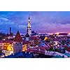 Aerial view of Tallinn Medieval Old Town illuminated in evening twilight, with dramatic sky Estonia