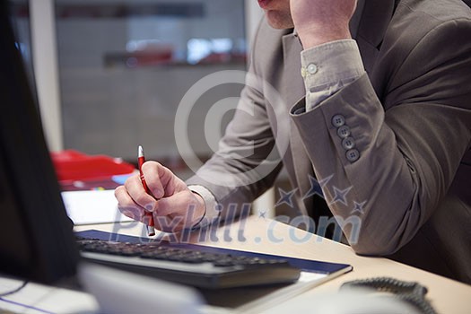 young business man working on computer and talking by phone on modern office indoors