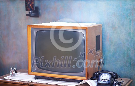 Vintage retro look living room detail. Television, telephone and clock on wooden old table Vintage retro look living room detail. Television, telephone and clock on wooden old table